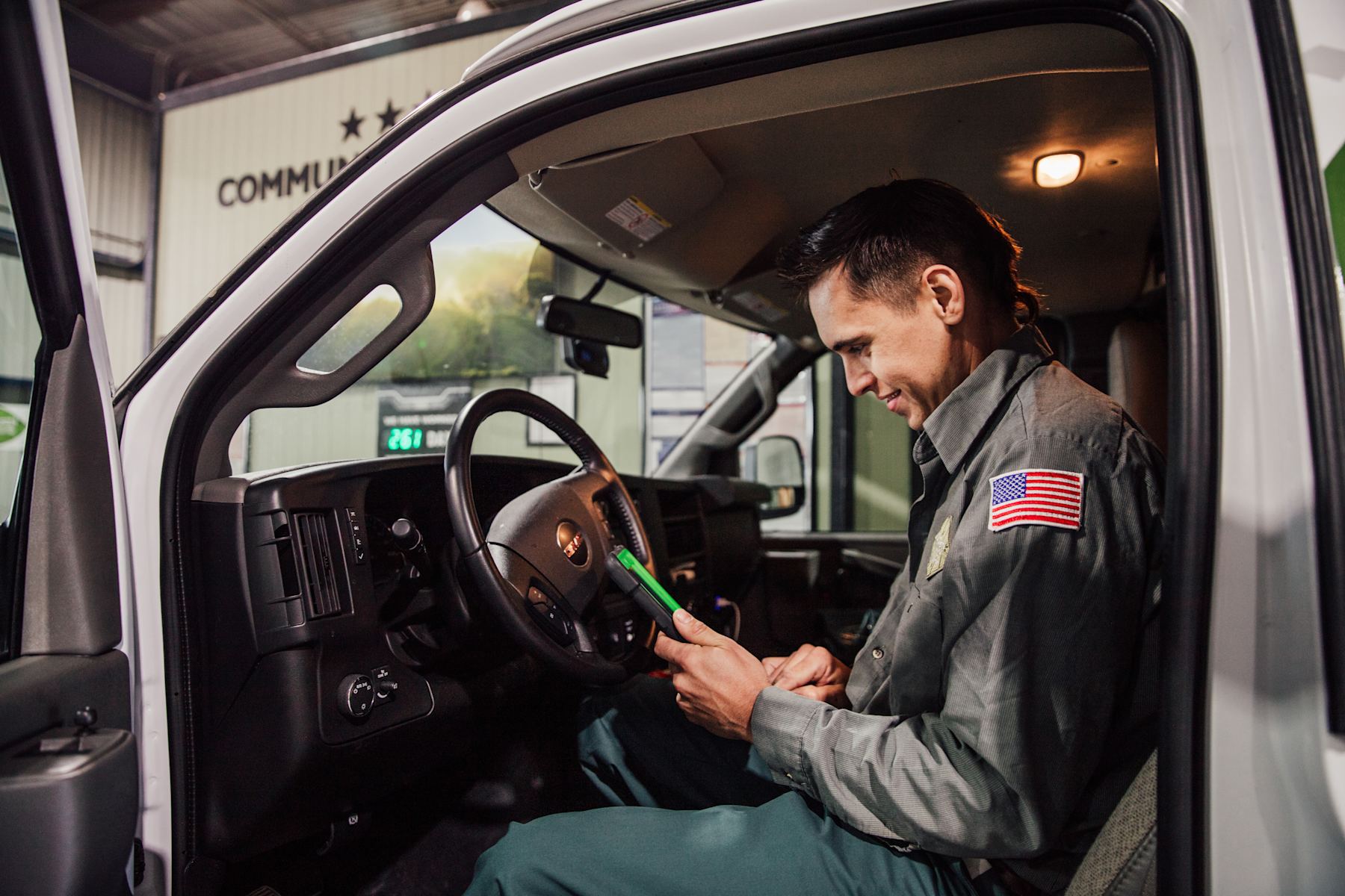 A technician in his service van checking a job on a tablet